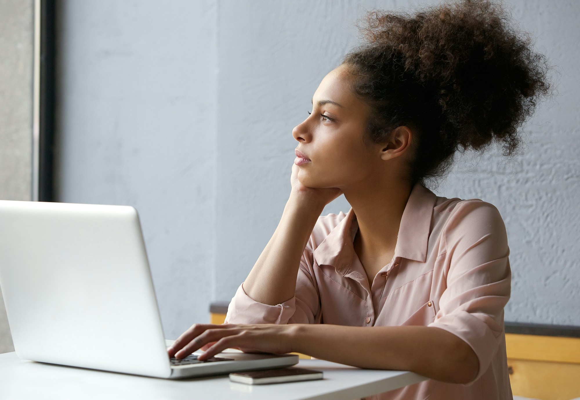 Young working woman looking out window